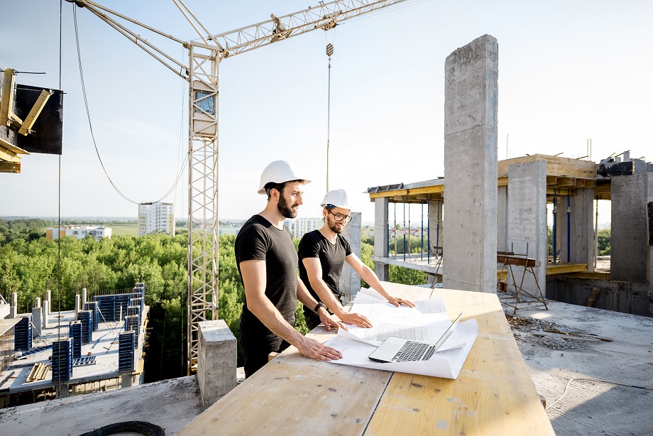 workers with drawings at the construction site